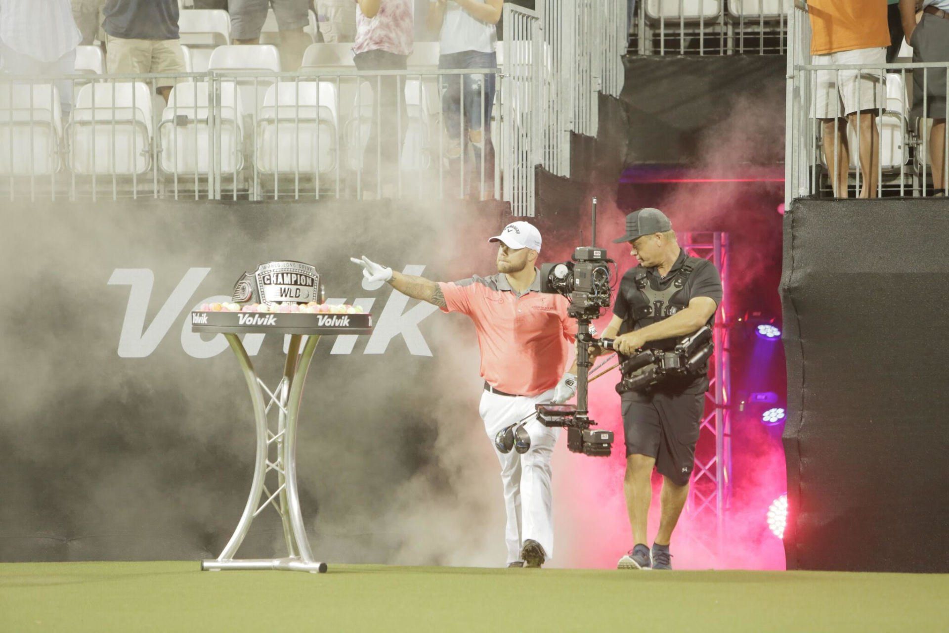 Man in a coral shirt and white pants competing in world championships