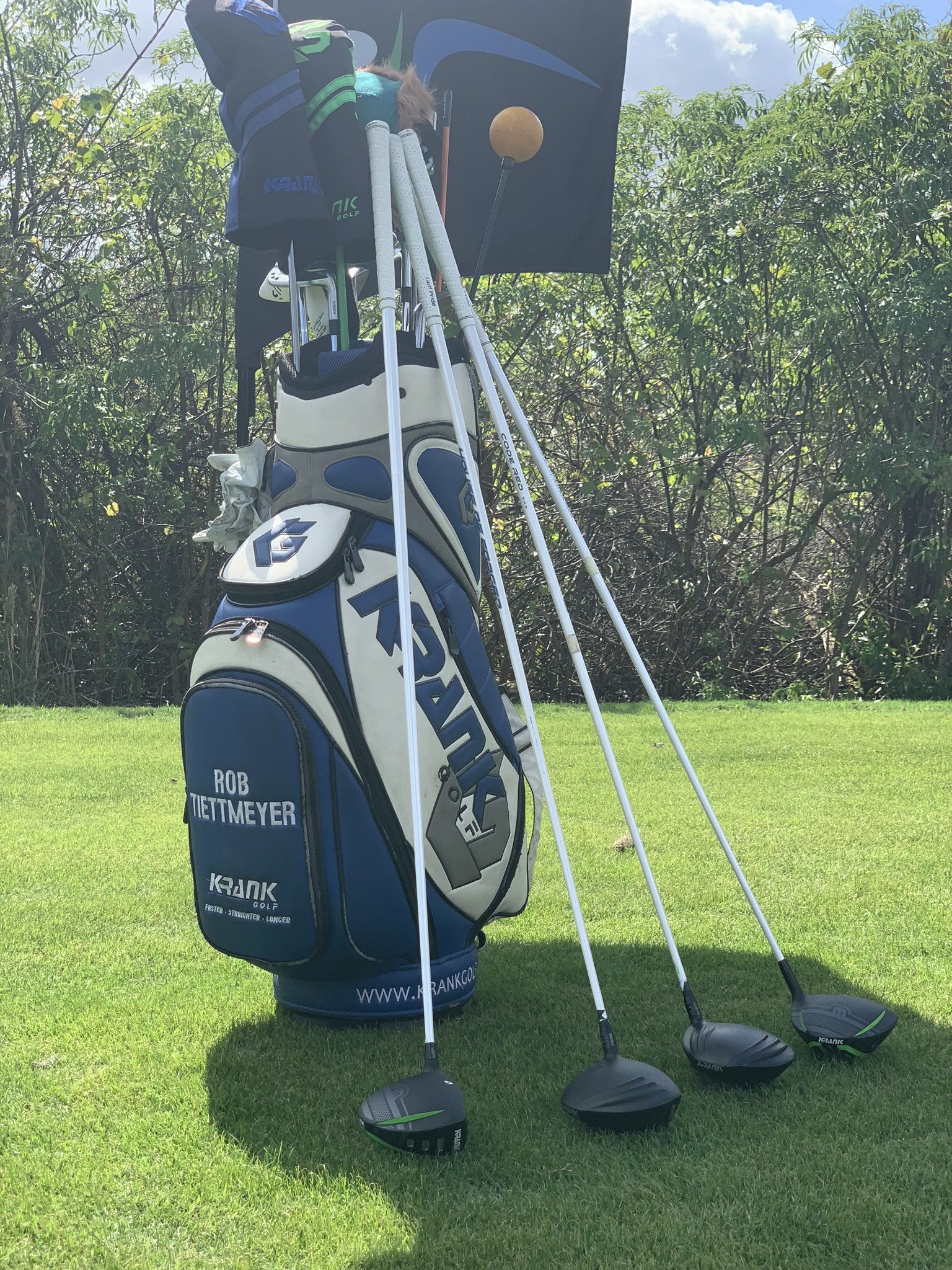 A golf bag and clubs are sitting on a golf course.