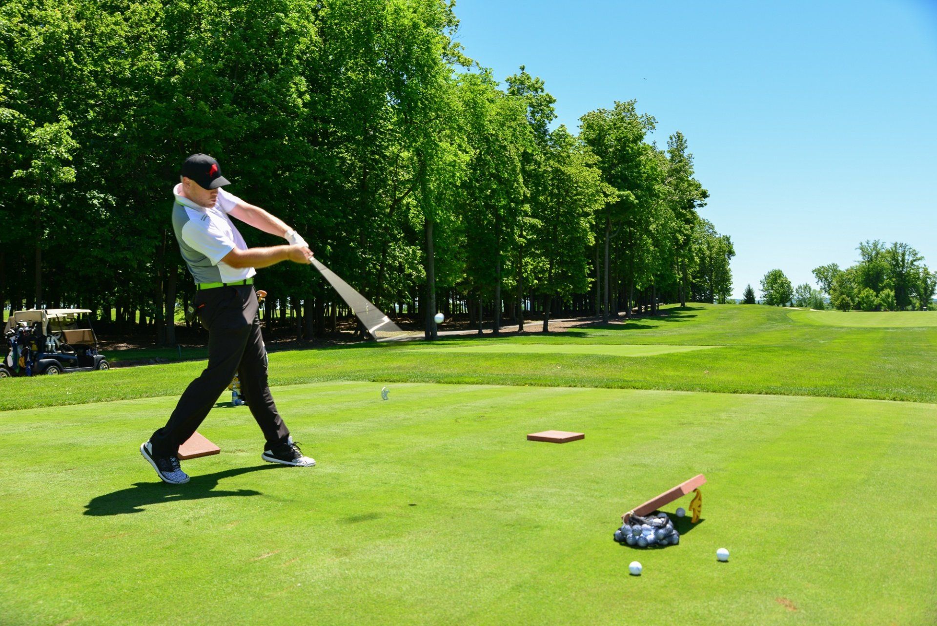 A man is swinging a golf club on a golf course