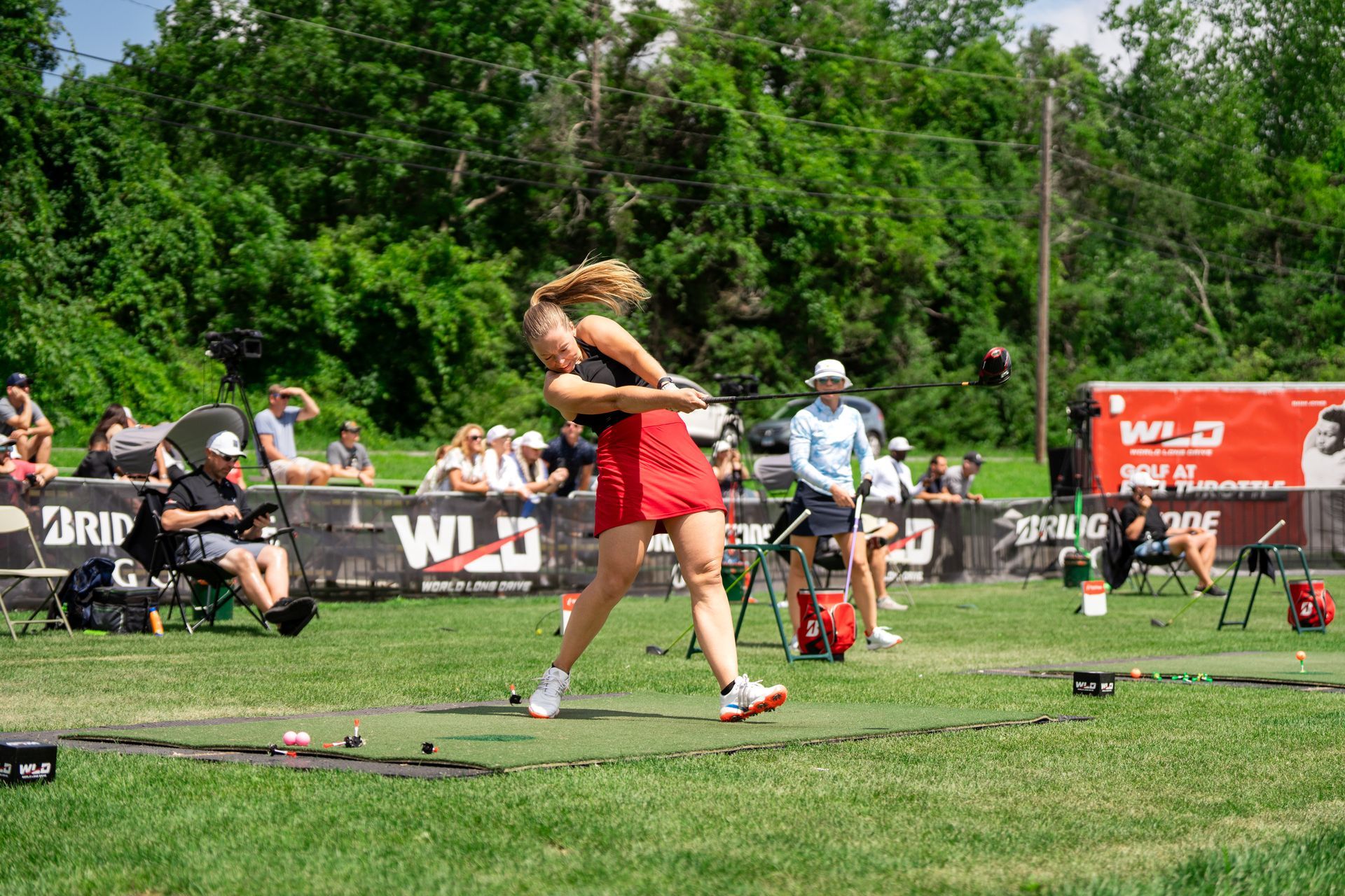 A woman is throwing a hammer in a field.