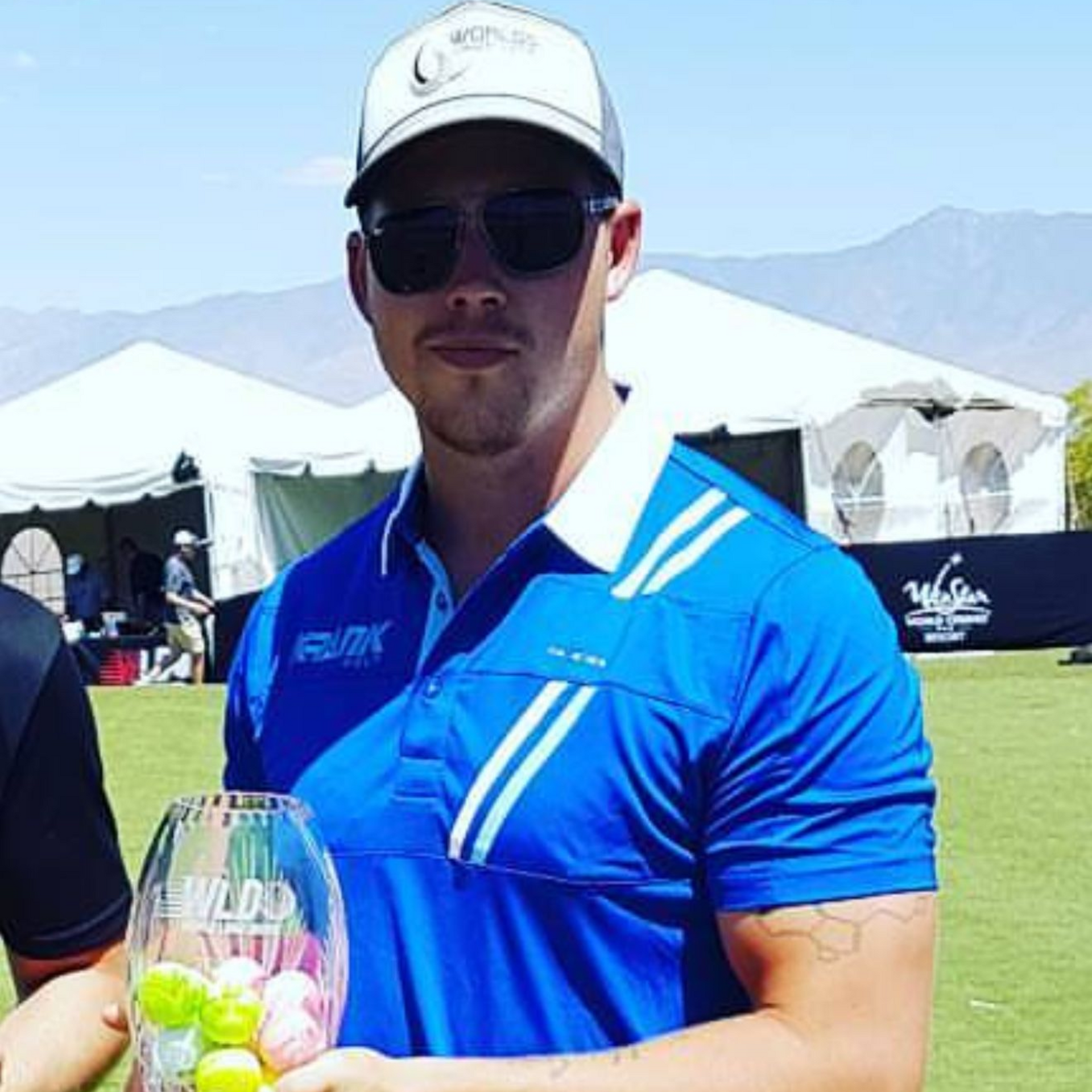 Golfer holding trophy.