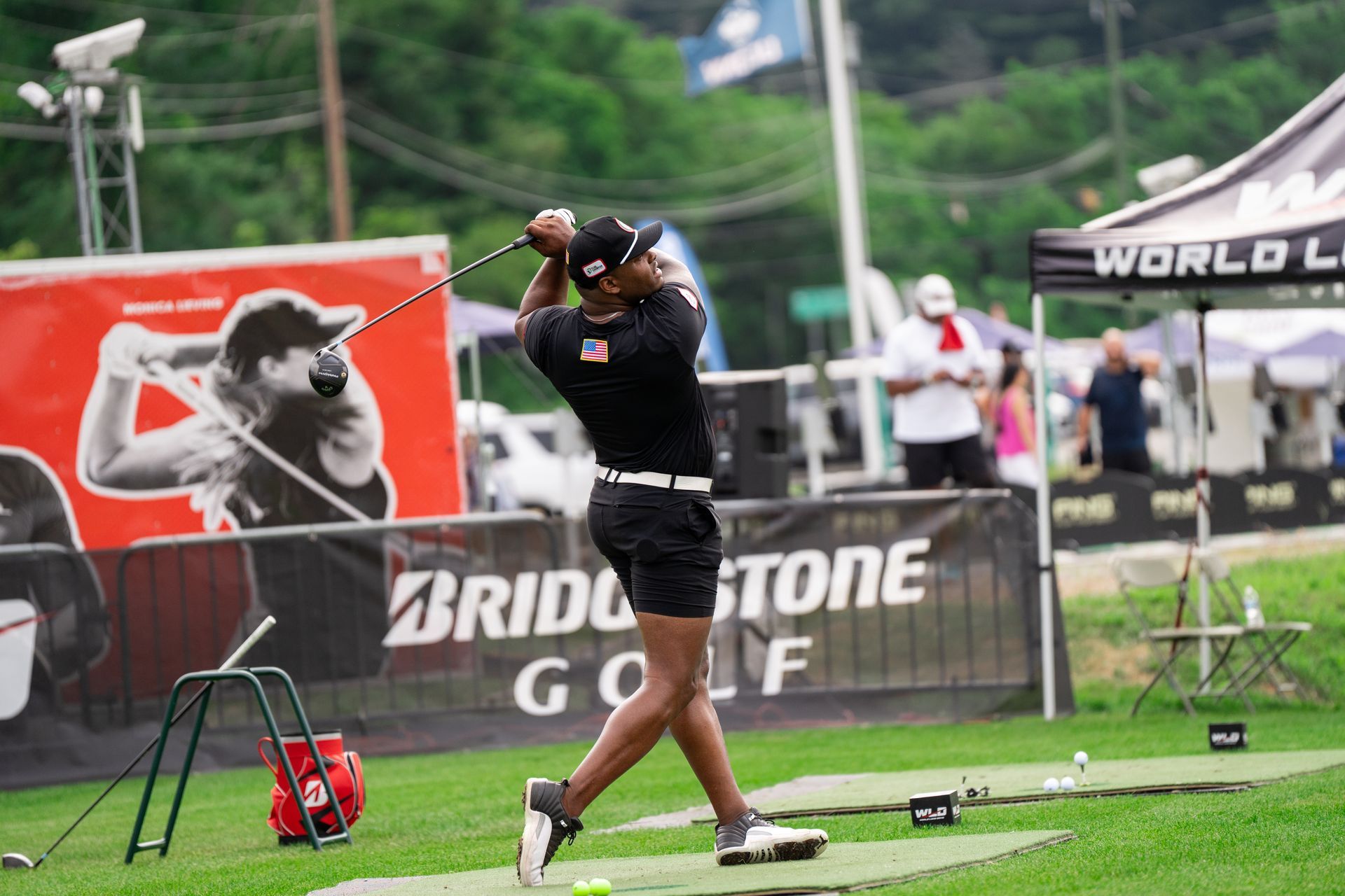 A man is swinging a golf club on a golf course.