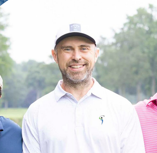A man wearing a hat and a white shirt is smiling for the camera.