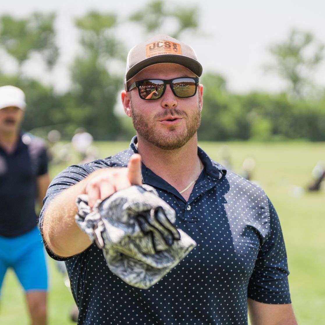 A man wearing sunglasses and a hat with the word tigers on it