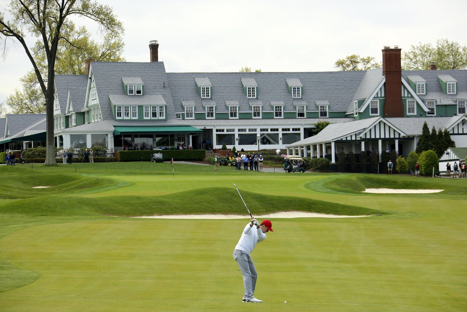 A man is swinging a golf club on a golf course