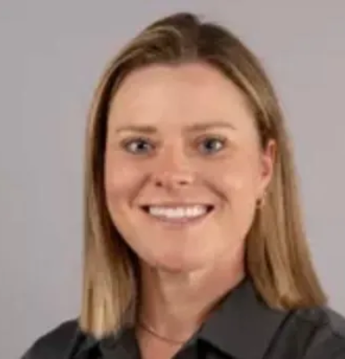 A woman wearing a yellow hat is sitting on a bench