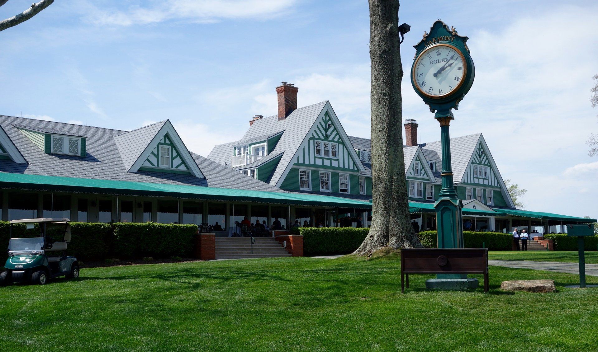 A large clock stands in front of a large building