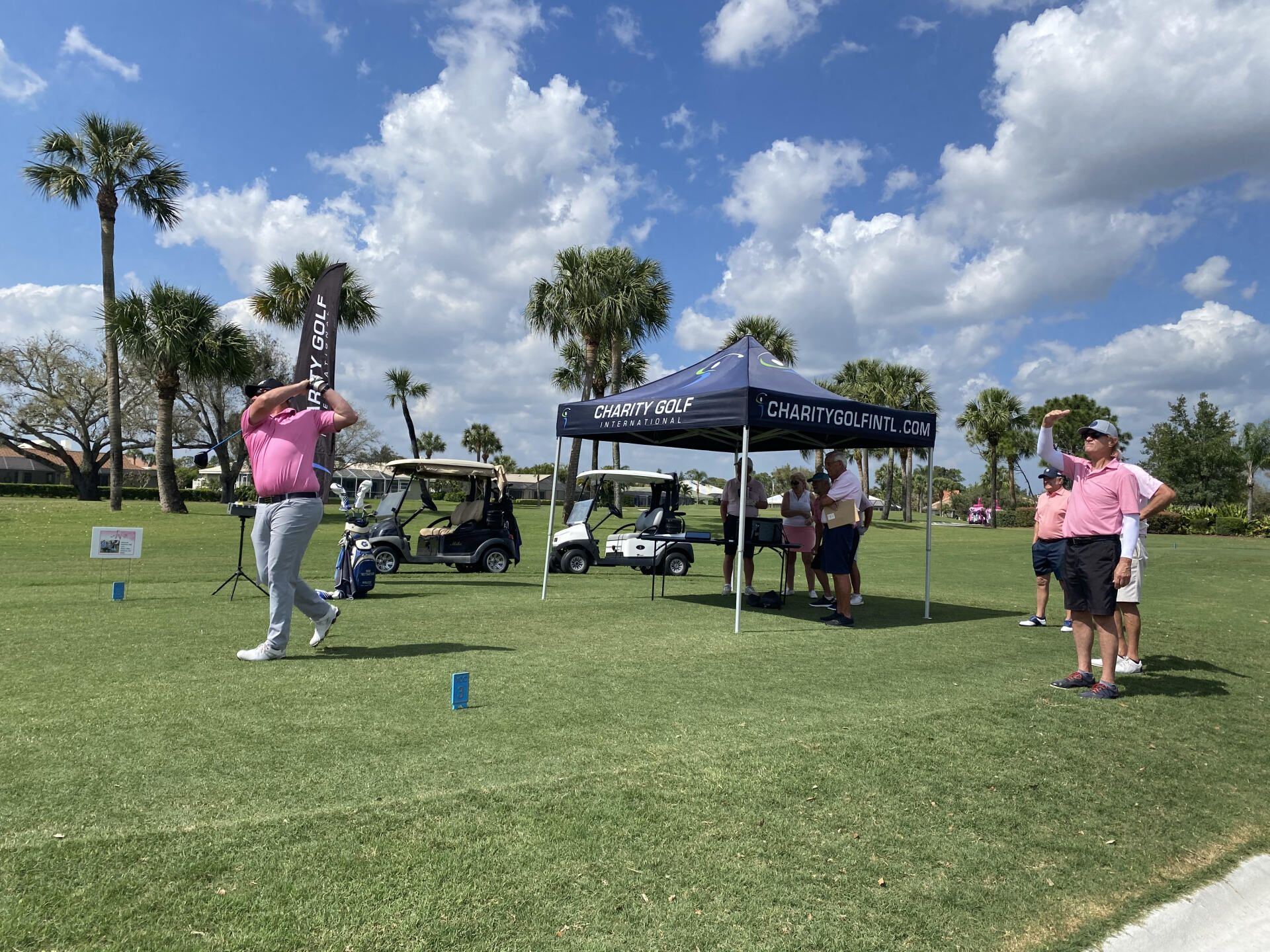 A man is swinging a golf club on a golf course.