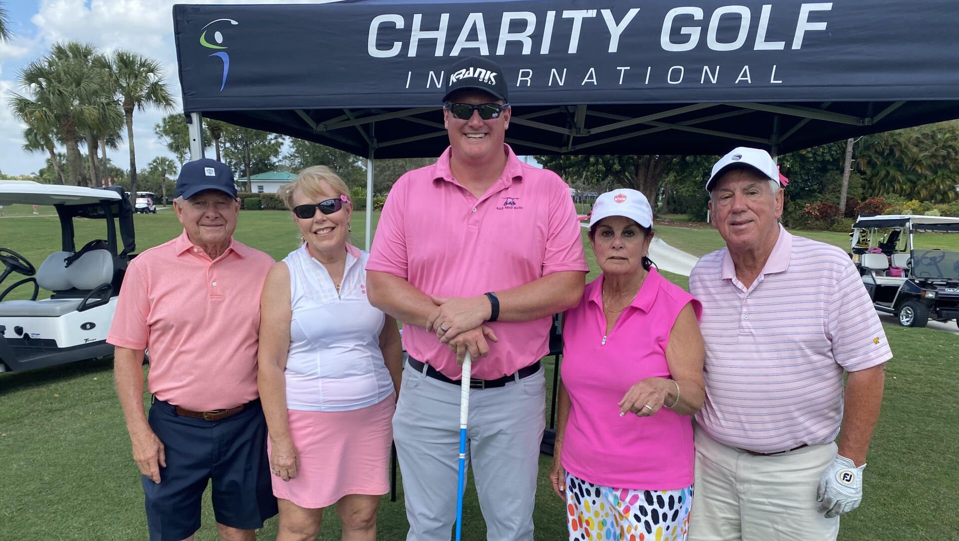 A group of people are posing for a picture on a golf course.