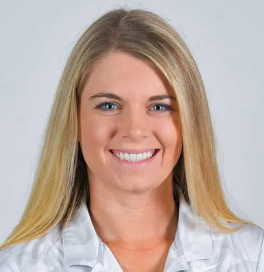 A woman wearing a yellow hat is sitting on a bench