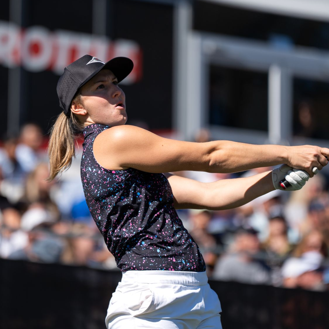 A woman in a green shirt is smiling in a circle
