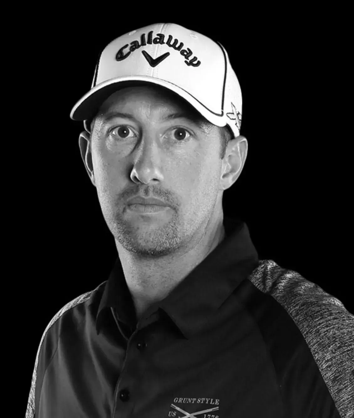 A black and white photo of a man wearing a callaway hat.