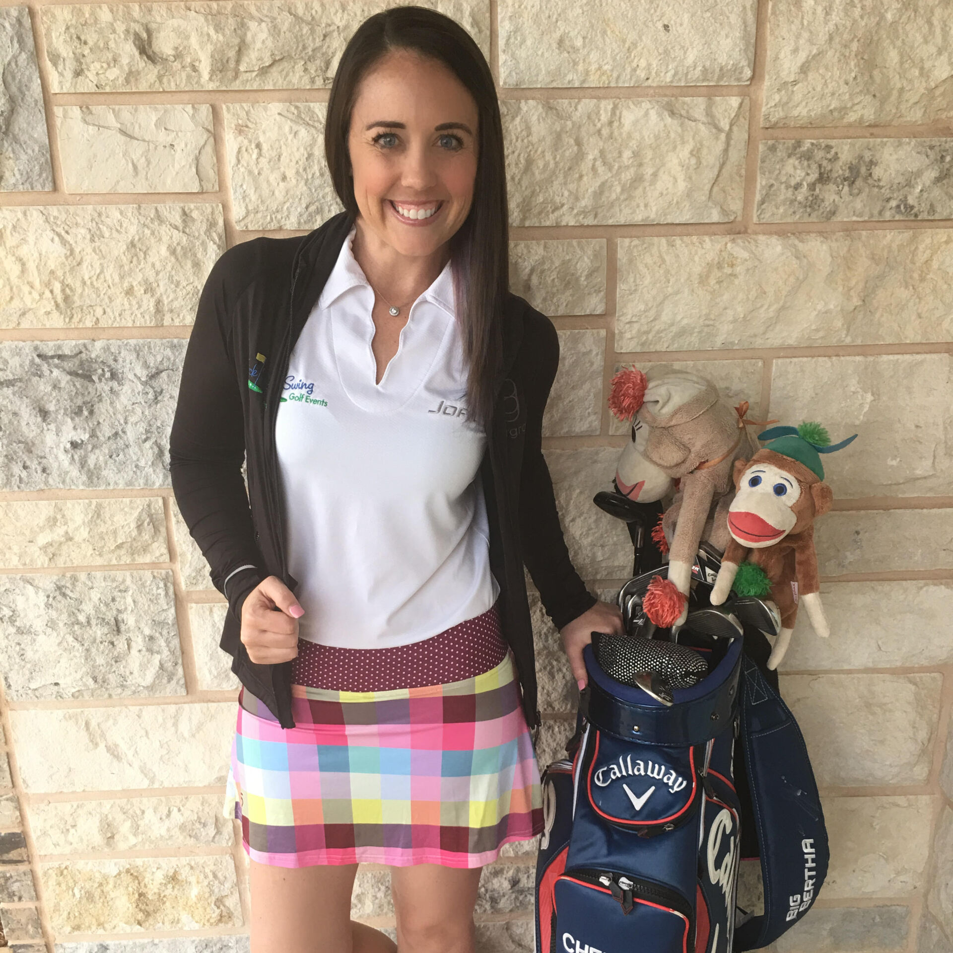 A woman standing next to a golf bag that says callaway