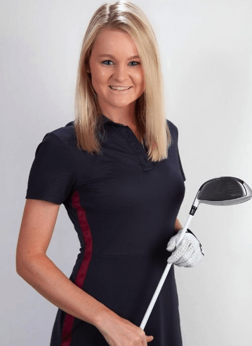 A woman in a black dress is holding a golf club.