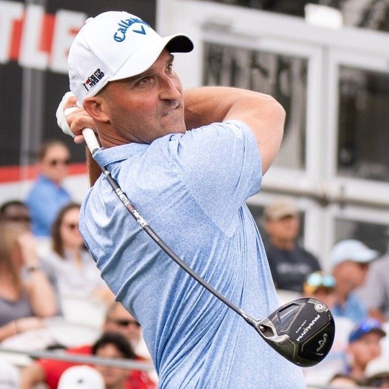 A man wearing a hat that says callaway is swinging a golf club