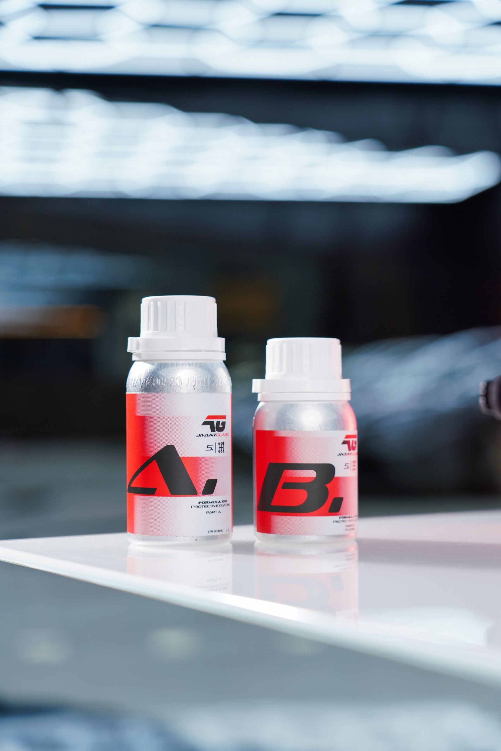 Two small red-and-white supplement bottles on a reflective surface, blurred background.