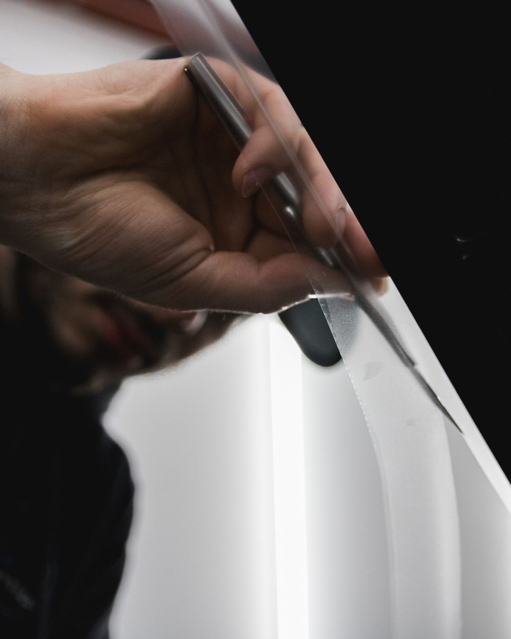 Hand using a pen to write on white paper close-up