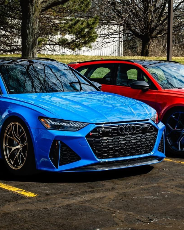 Blue Audi sports car parked beside a red car outdoors in a lot