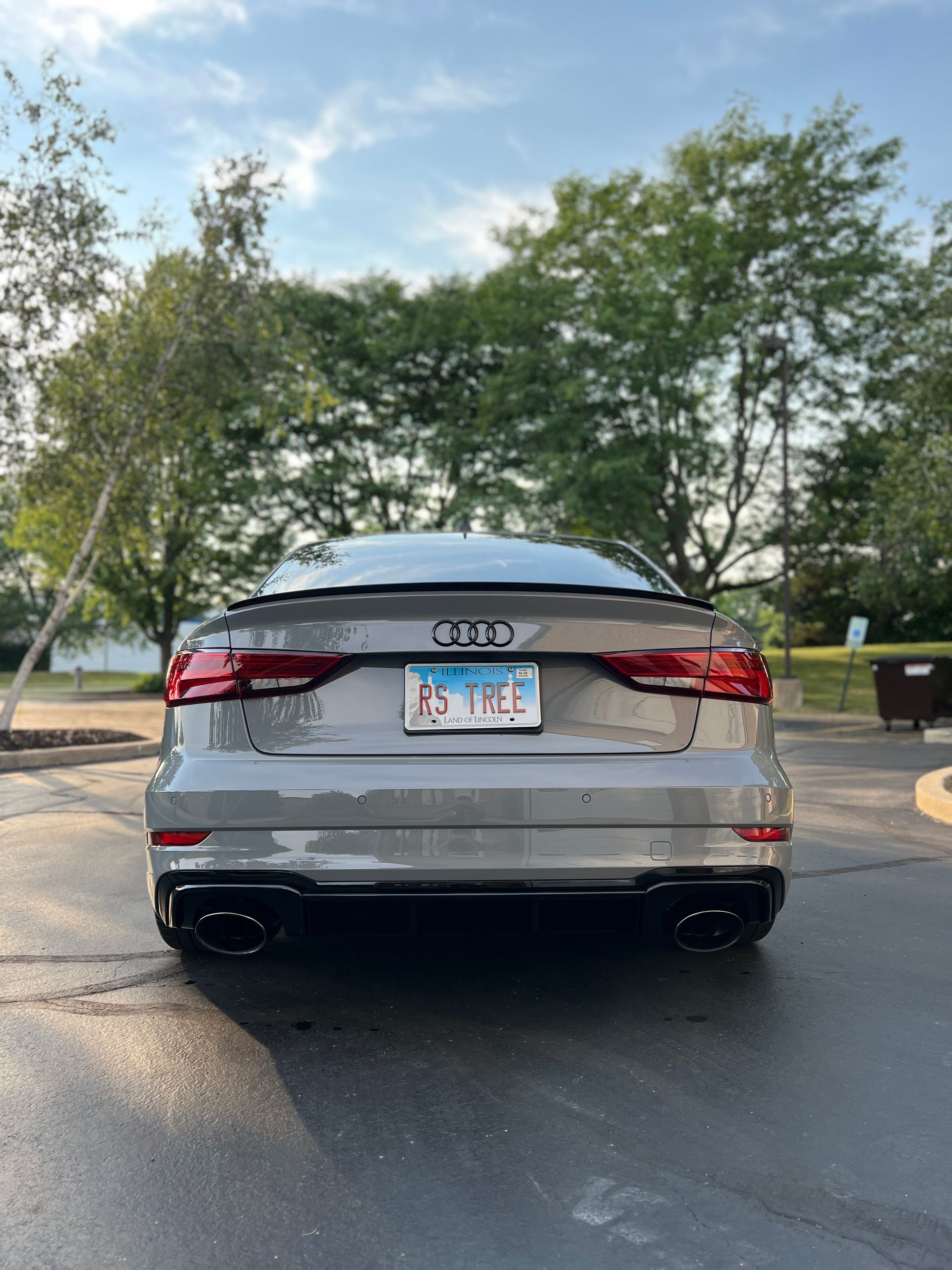 Silver Honda sedan parked on a road near trees, rear view, with a Florida license plate