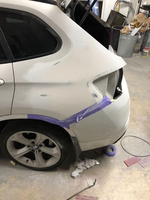 a white bmw is being painted in a garage