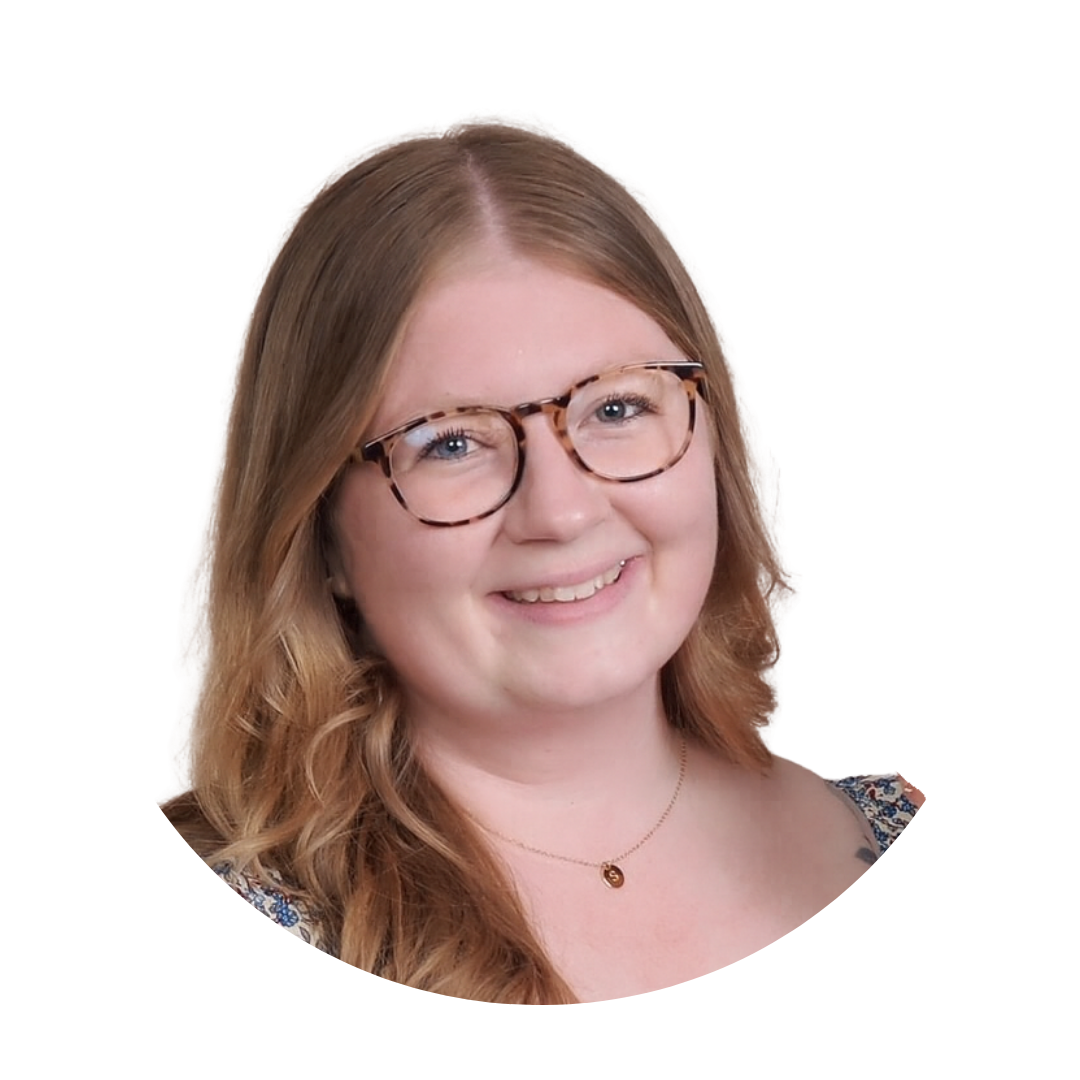 Woman with blonde hair wearing a pink blazer, smiling.