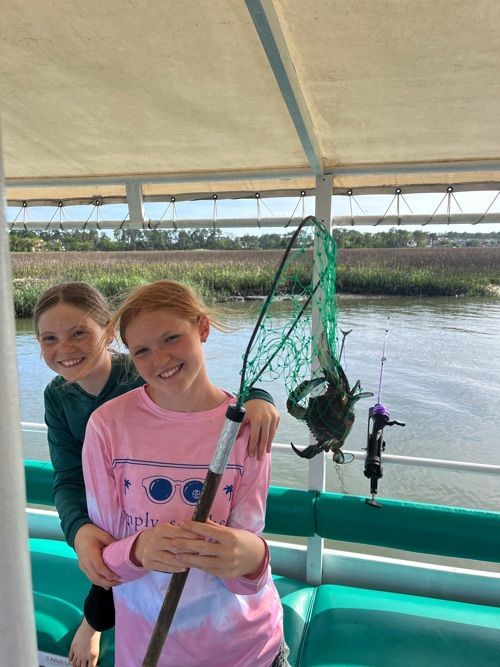 Kids catching a crab in Hilton Head Island on crabbing boat tour.