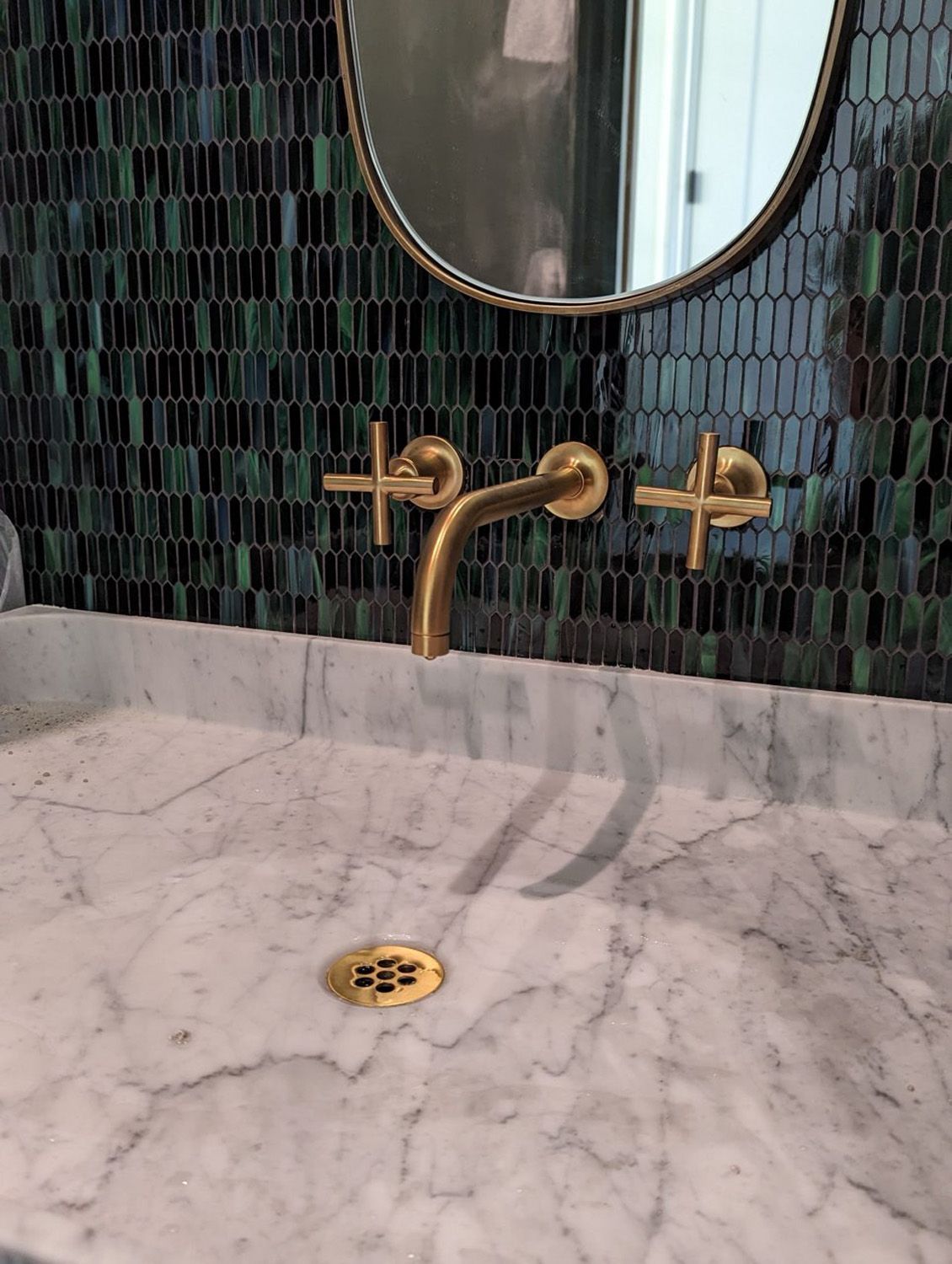 A kitchen sink with a faucet and a window in the background.