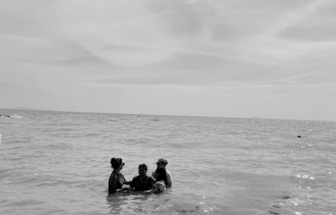 A group of people are getting baptized in the ocean.