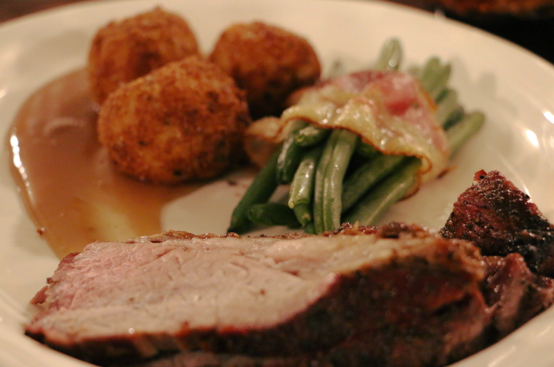 A white plate topped with meat and green beans