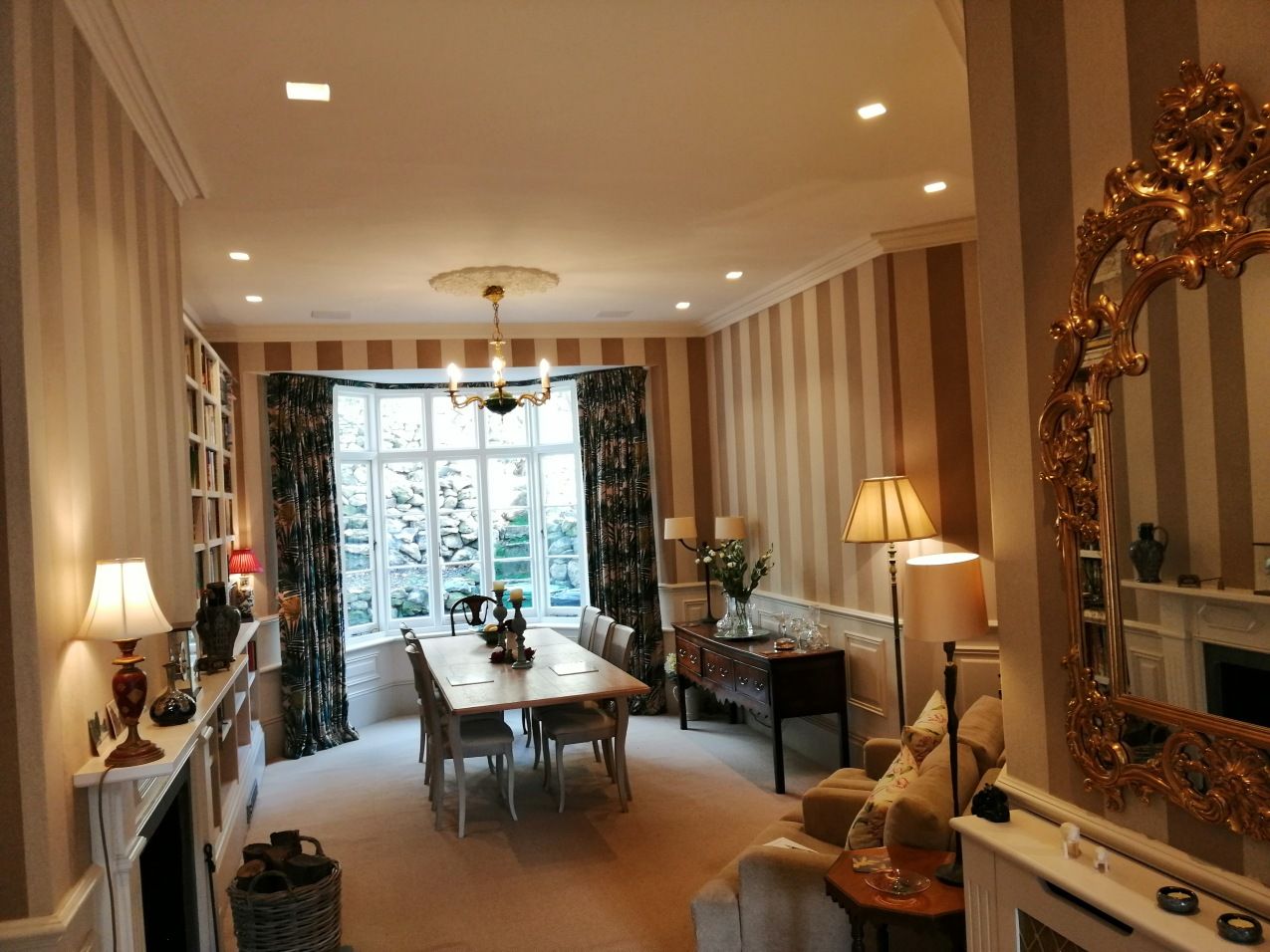 A living room with a table and chairs and a mirror