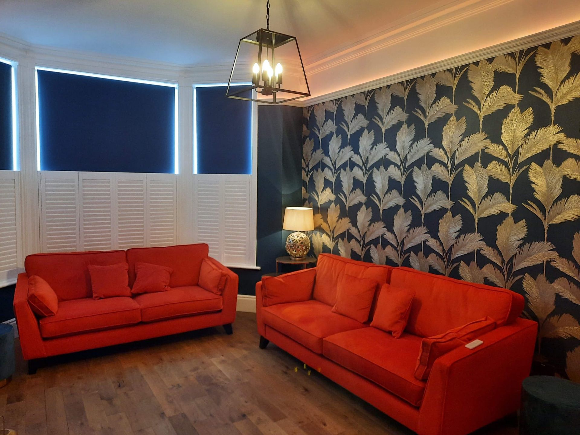 A living room with two red couches and a lamp.