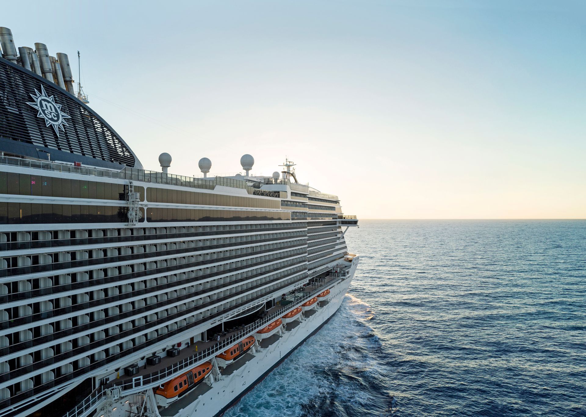 Large cruise ship sailing on a calm ocean under a clear sky.