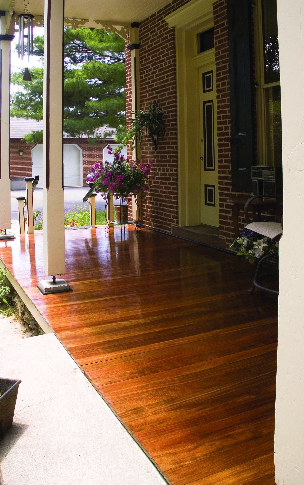 A porch with a wooden floor and a brick wall Galebach’s Floor Finishing