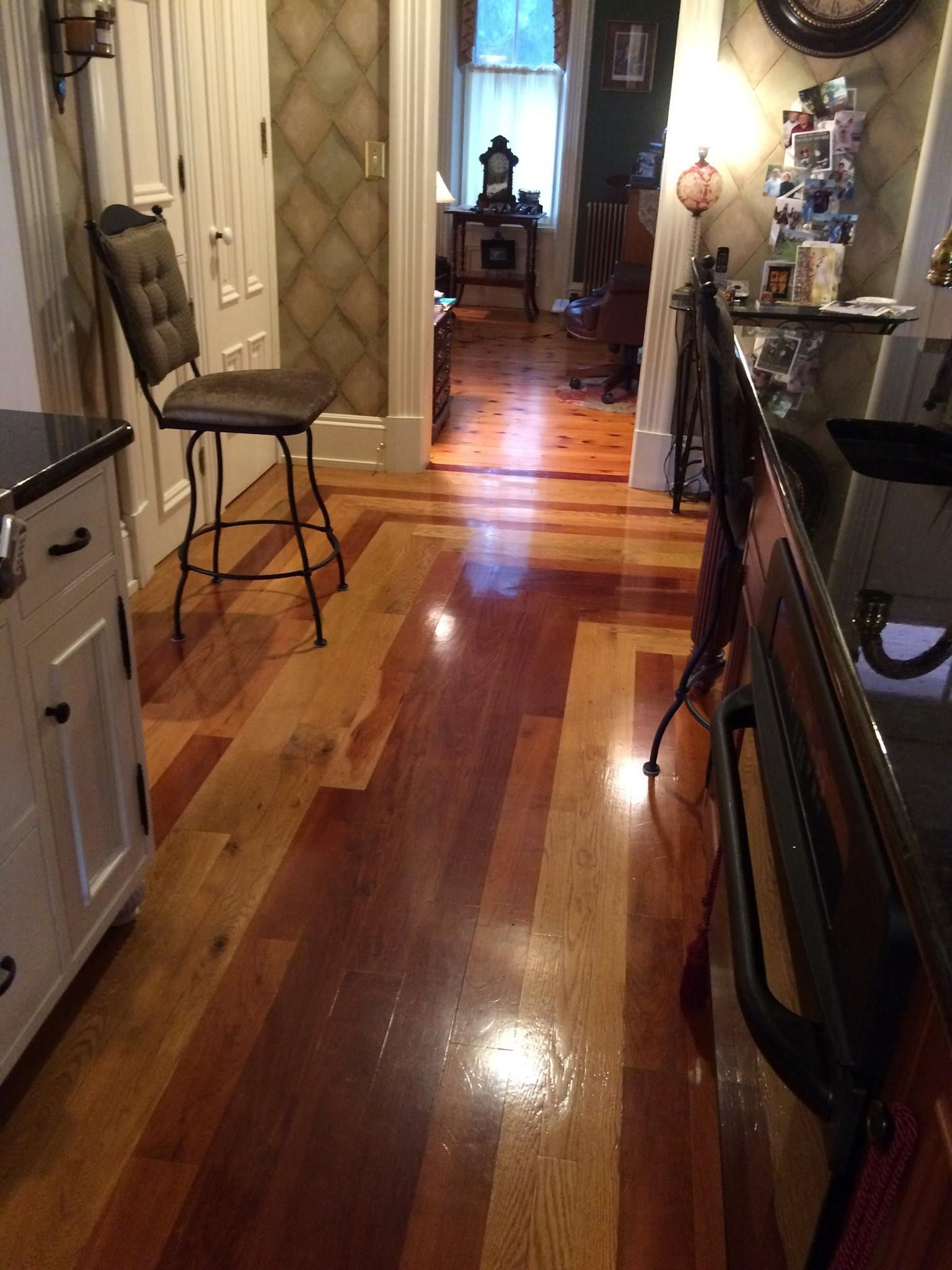A kitchen with a wooden floor and a chair Galebach’s Floor Finishing