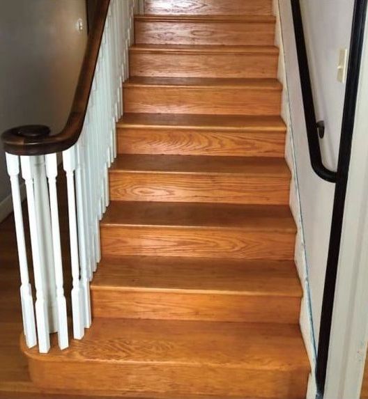 A set of wooden stairs with a white railing