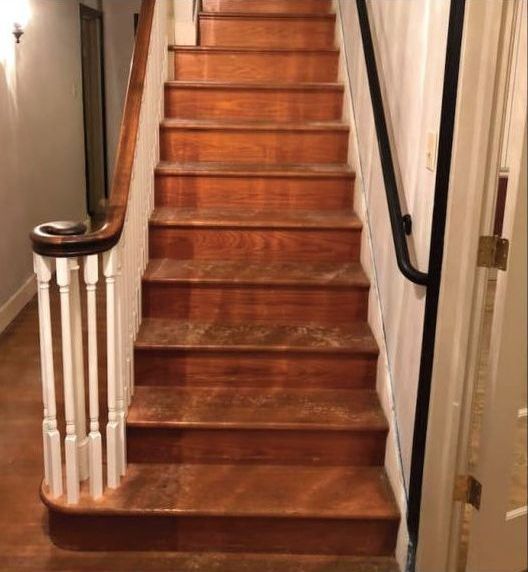 A wooden staircase with a white railing in a hallway