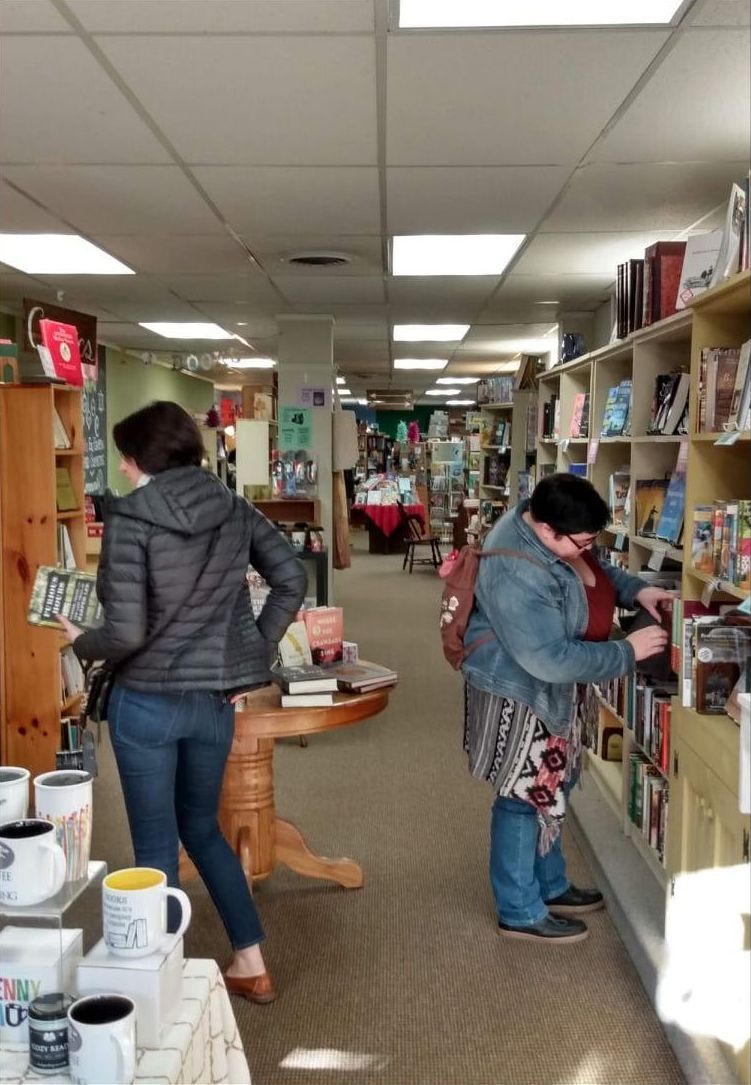 A woman is looking at a book in a bookstore