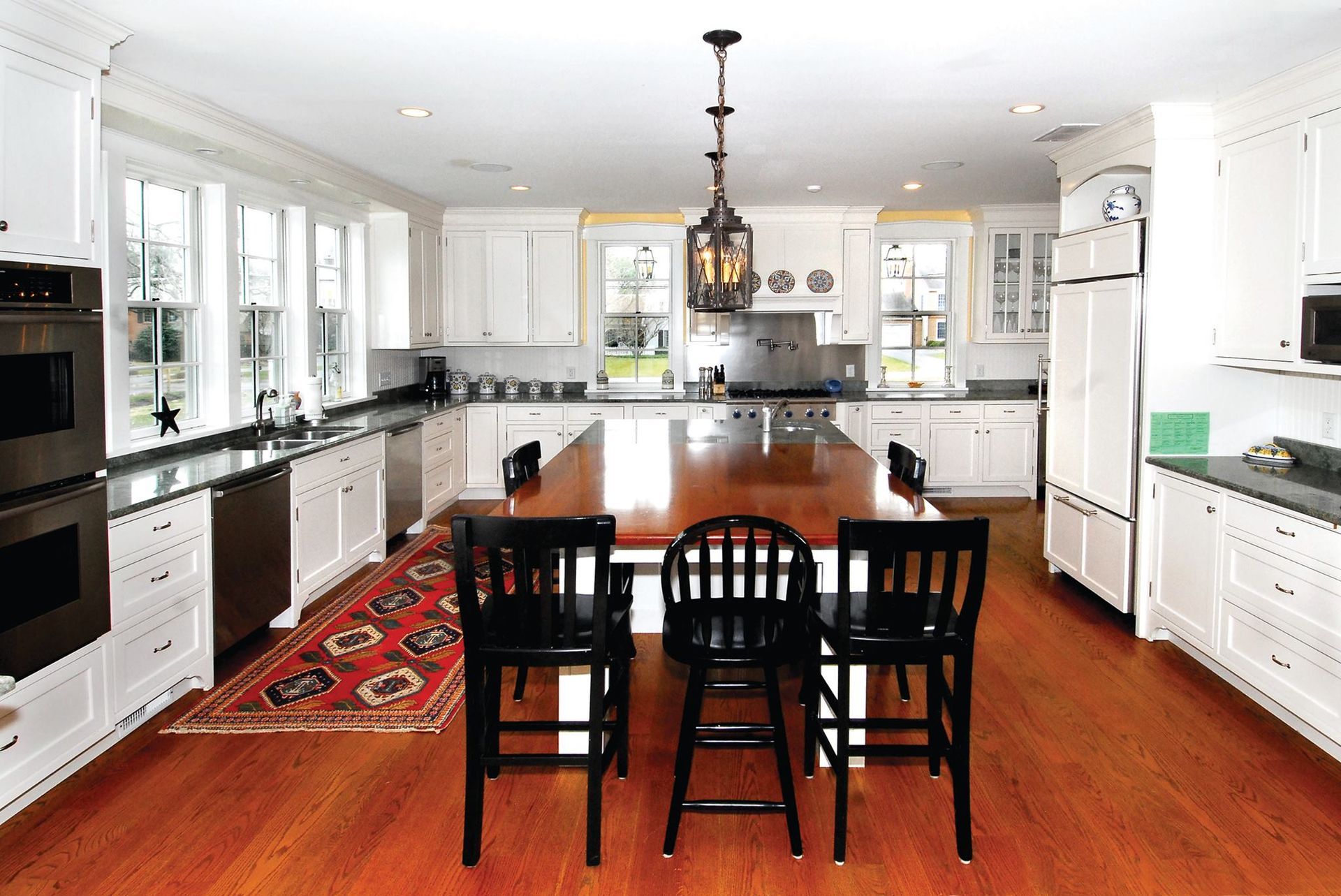 A kitchen with a table and chairs in it with a refinished hardwood floor