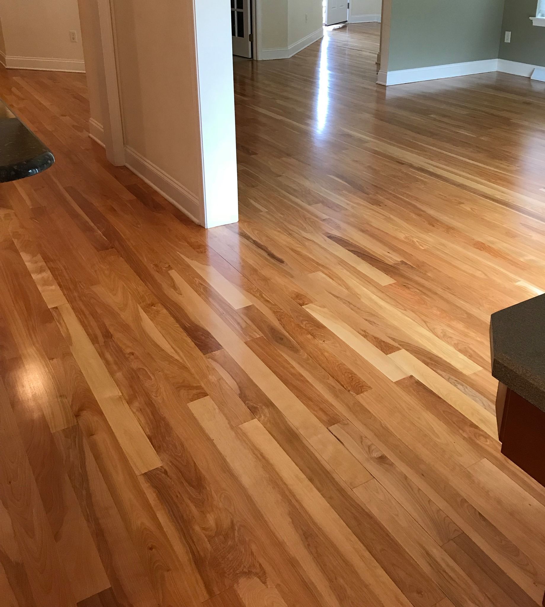 A wooden floor in a room with a table in the foreground Galebach’s Floor Finishing