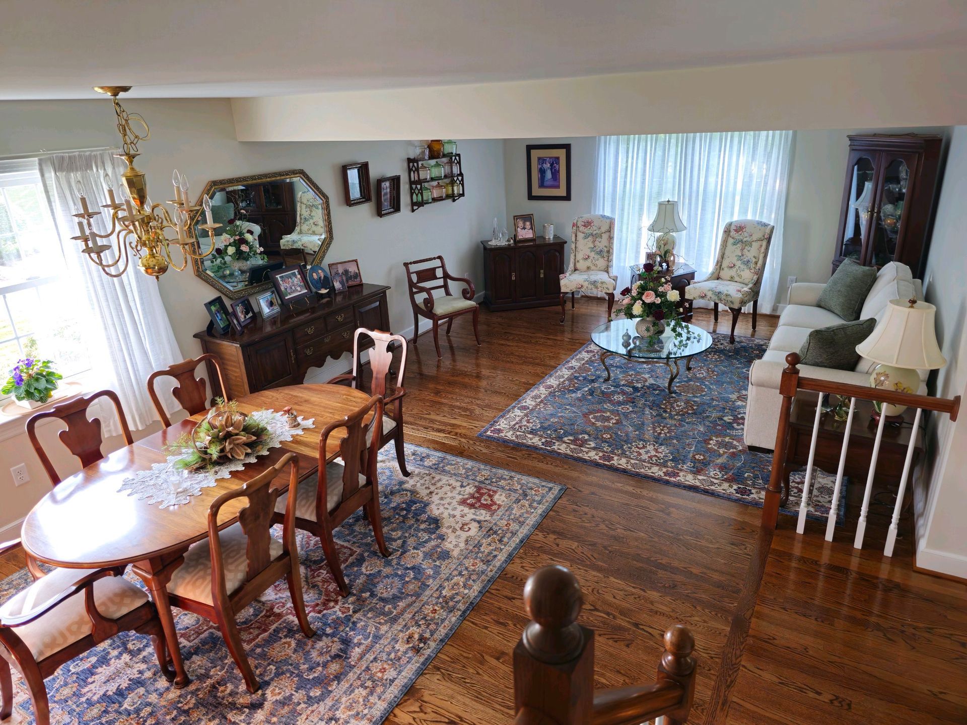 A living room with a table , chairs , a couch and a rug.