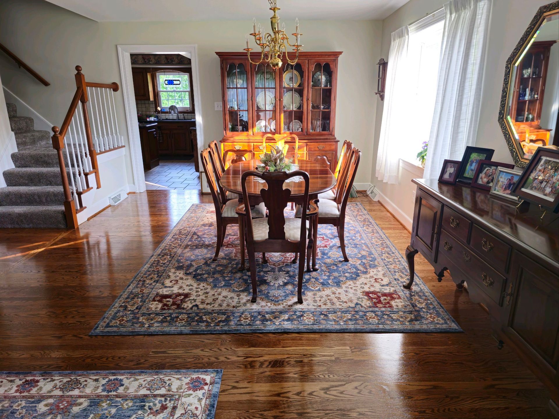 A dining room with a table and chairs and a rug