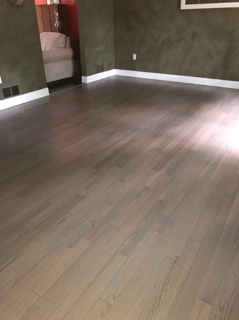 A living room with hardwood floors and green walls.