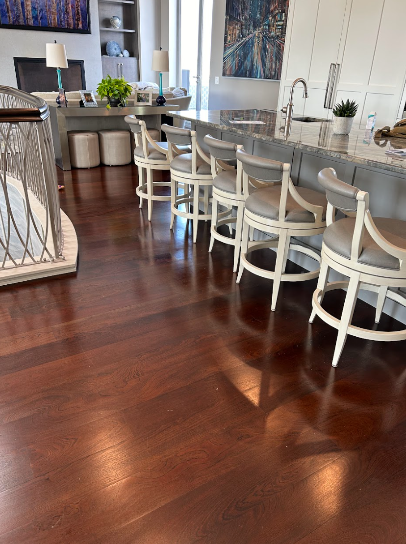 A living room with hardwood floors and white chairs by Galebach’s Floor Finishing