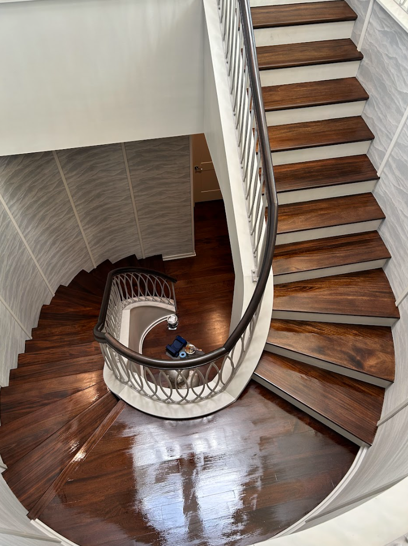 A spiral staircase with wooden steps and a metal railing Galebach’s Floor Finishing