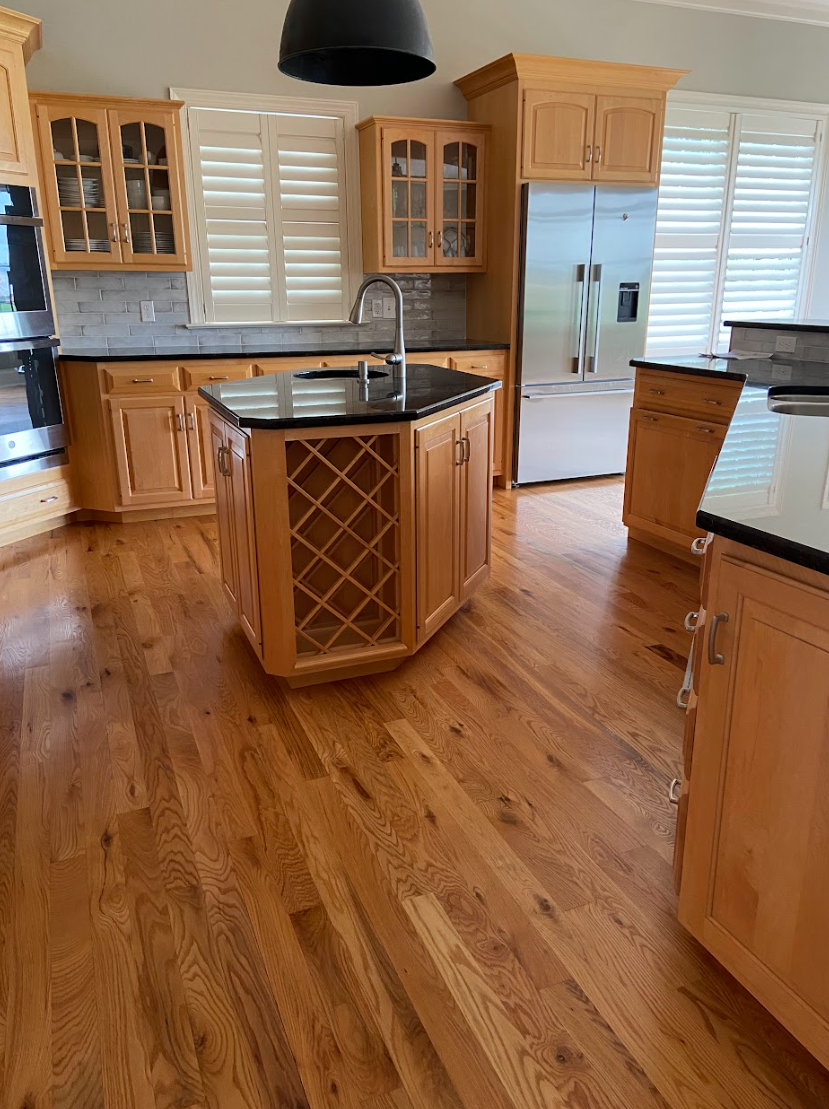 A kitchen with wooden cabinets and a wine rack on the island