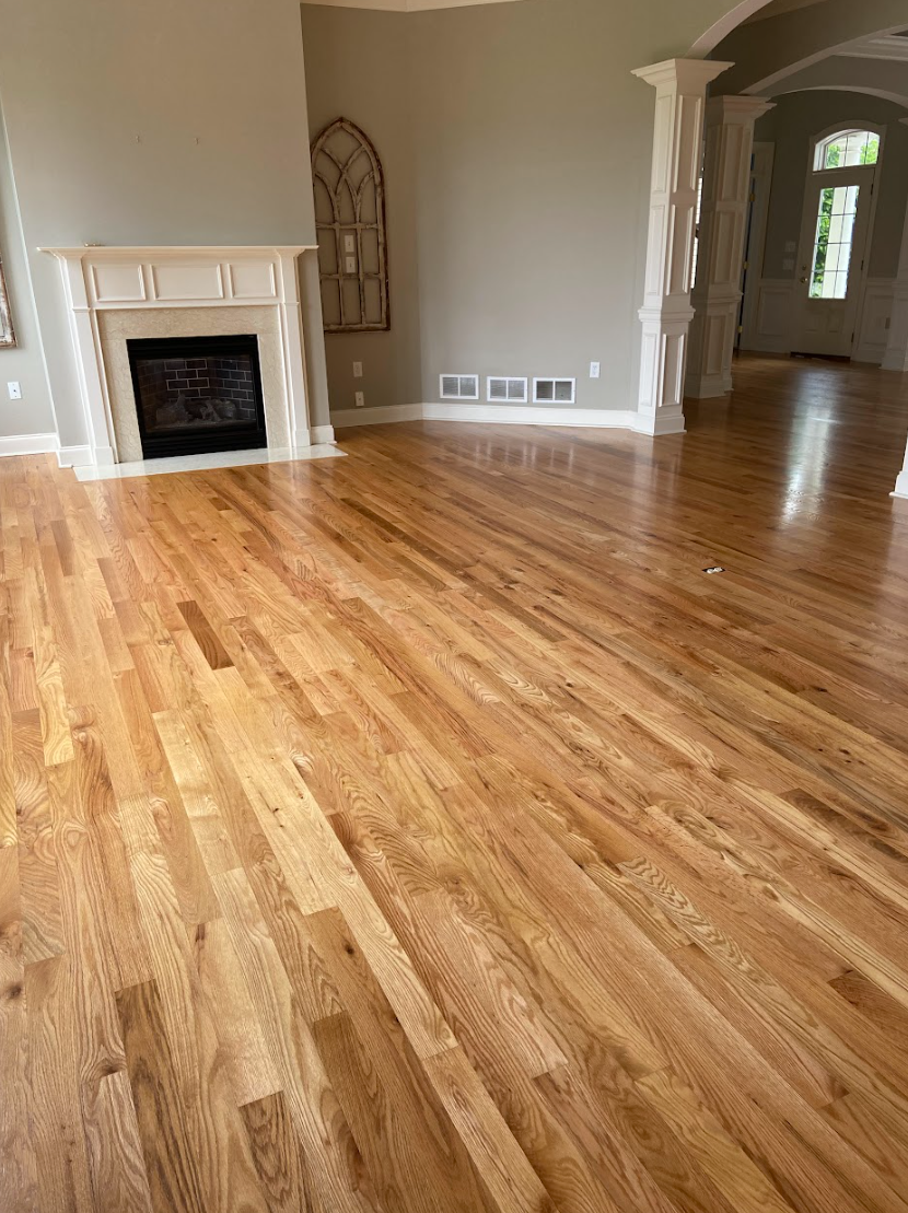 A living room with hardwood floors and a fireplace.