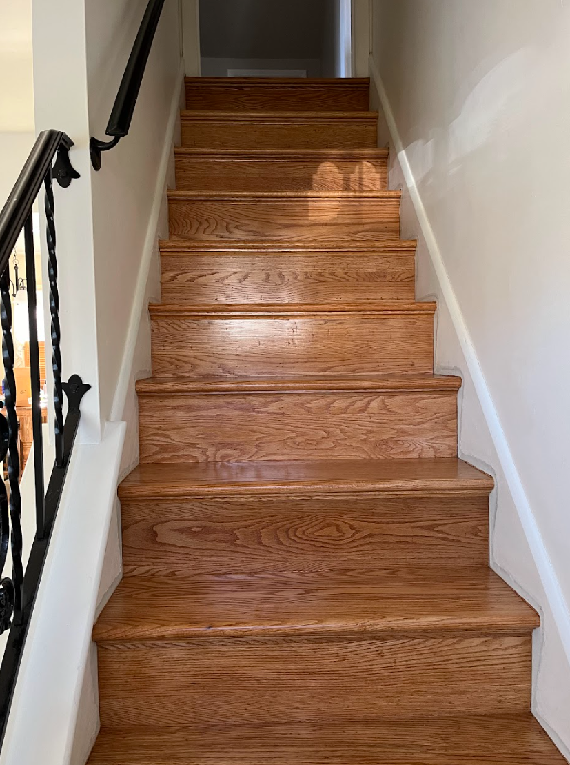 A set of wooden stairs leading up to the second floor of a house.