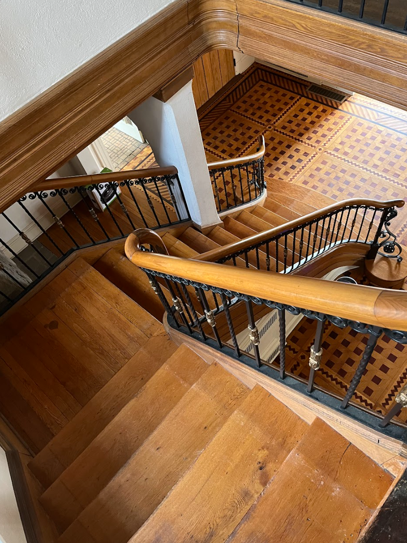 An aerial view of a wooden staircase with a metal railing.