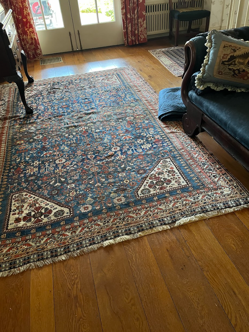 A living room with a rug on the floor and a couch.