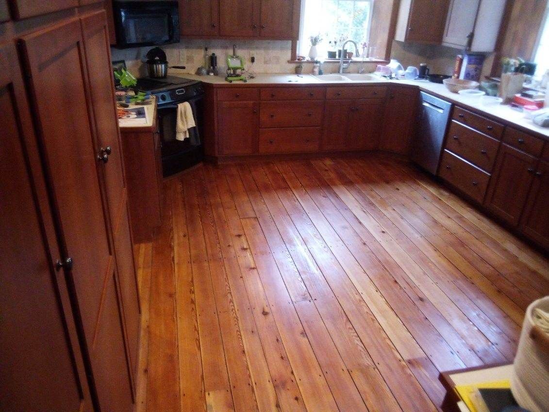 A kitchen with a wooden floor and cabinets